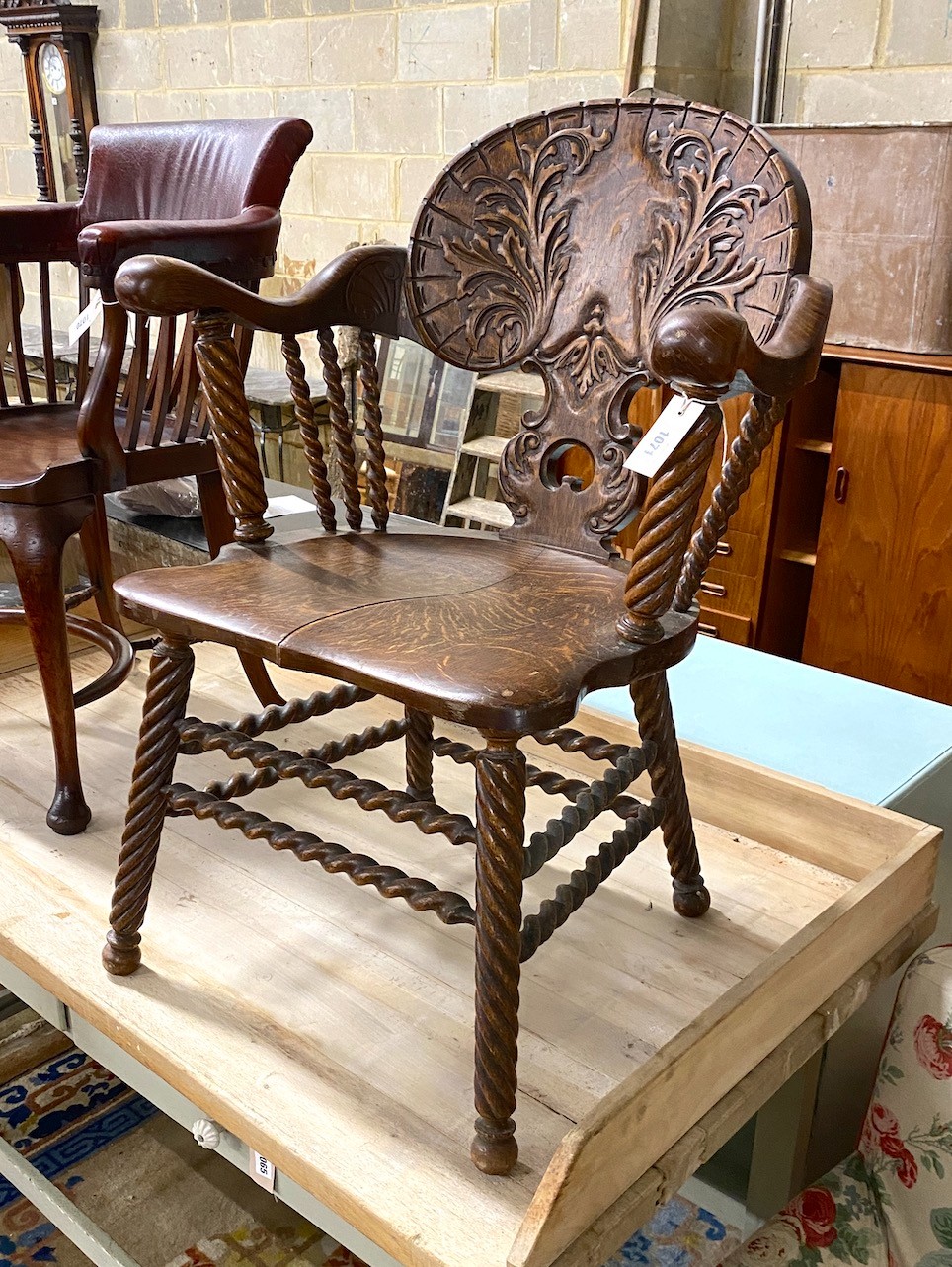 A 19th century Continental carved oak tub framed elbow chair on turned spiral underframe, width 65cm, depth 50cm, height 89cm